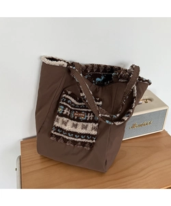 Detail of winter tote bag featuring brown canvas and plush fleece pocket with star-picking label