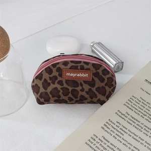 Detailed view of mini leopard print shell pouch with zipper and leather brand tag