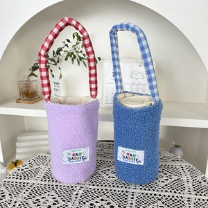 Detail of plush water bottle sleeve with textured faux fur and checkered handles