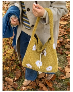 Detail of plush tote bag with flower embroidery and drawstring in autumn outdoor setting