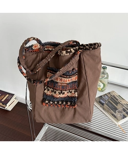 Detailed view of the brown canvas tote bag with jacquard plush pocket and star-picking tag