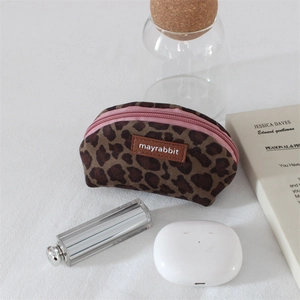 Leopard print velvet shell pouch with pink zipper and luxury cosmetic accessories