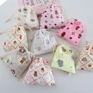 Flat lay of colorful seersucker drawstring bags with cute cartoon prints and 3D texture