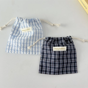 Detail of blue plaid cotton drawstring storage bags with mayrabbit label and cream ropes