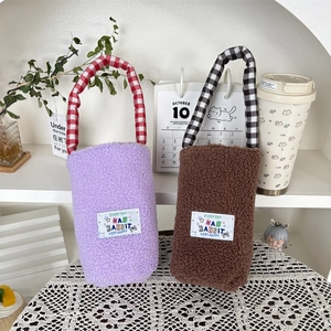 Detail of plush lamb-like wool water bottle sleeves with checkered handles in ins-style