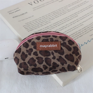 Close-up of leopard print suede coin purse with pink zipper and leather logo label