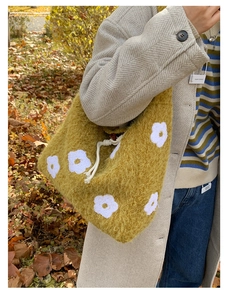 Detail of yellow plush tote bag with white flower embroidery and drawstring closure