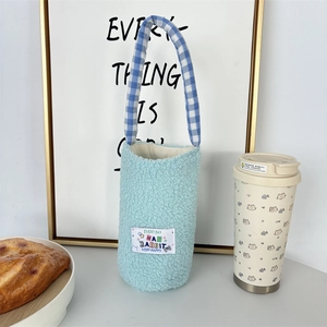 Detail of light blue fuzzy water bottle bag with rabbit patch and checkered handle