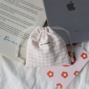 Detailed view of pink plaid drawstring storage bag with May Rabbit label on fabric