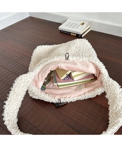 Spacious white plush tote bag with pink lining showing interior capacity for books