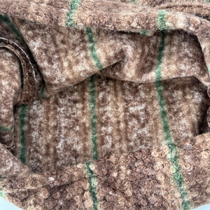Close-up of the plush brown boucle texture with green stripe pattern on a tote bag