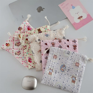 Flat lay of five floral embossed drawstring pouches with cute cartoon animal patterns