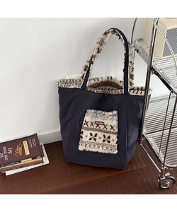 Detail of navy canvas tote bag featuring ethnic snowflake pattern plush pocket texture