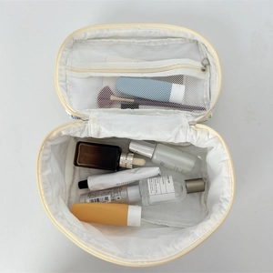 Vue détaillée de dessus d'une trousse de maquillage blanche matelassée ouverte avec filet