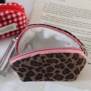 Detail of leopard print velvet shell pouch with pink zipper and soft white lining