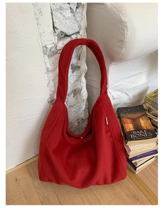Close-up of red large wool shoulder bag with soft textured fabric and slouchy design