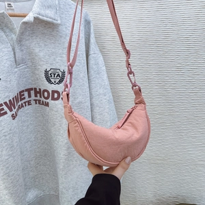 Detail of pink half-moon nylon crossbody bag showing the wrinkled texture and zipper