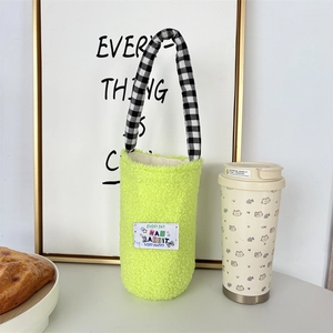 Close-up of fuzzy neon green bottle carrier with black and white checkered handle