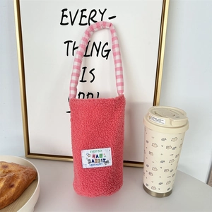 Pink plush water bottle carrier with a checkered handle and cute cartoon rabbit label