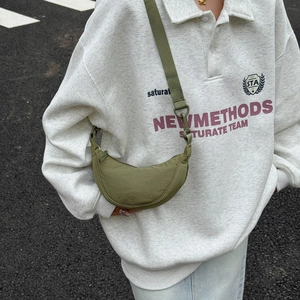 Close-up of olive green nylon crossbody bag showing water-resistant texture and strap detail