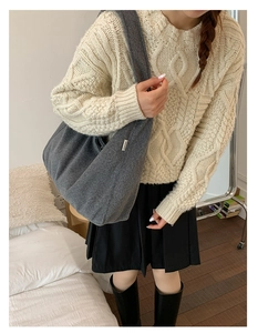 Lifestyle view of a large grey felt hobo bag styled with a cable knit sweater and boots