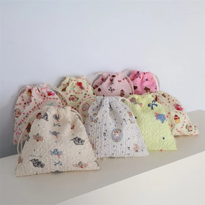 Detail of embossed bubble fabric drawstring bags with cute cartoon patterns