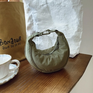 Detailed close-up of olive green nylon crescent bag with adjustable buckle and zipper