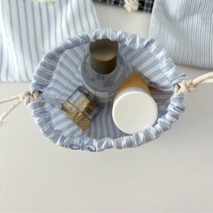 Blue striped drawstring bag interior showing storage capacity for toiletries