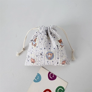 Detail of blue striped drawstring storage bag featuring a cute cartoon bear print
