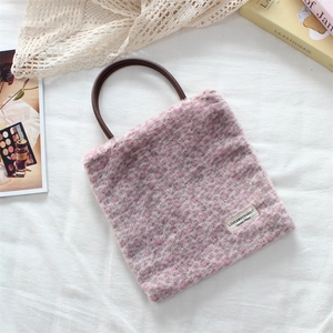 Pink leopard print faux fur tote bag with round brown handles on a white lace background