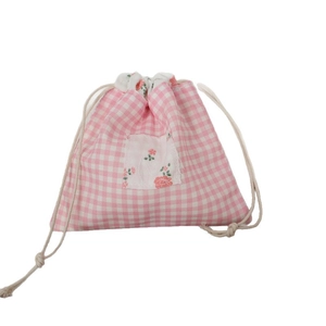 Pochette de rangement à carreaux roses et blancs avec écusson floral rose sur fond blanc