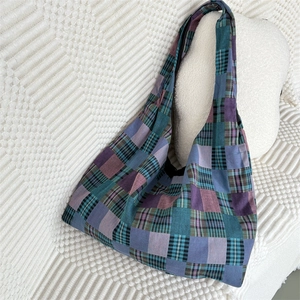Detail of multi-color plaid patchwork tote bag on a cozy white textured background