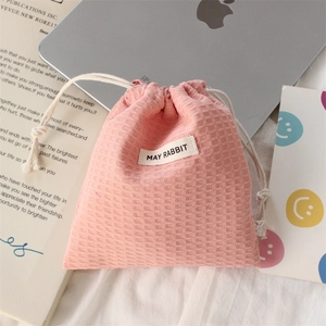 Detailed texture of pink waffle drawstring pouch for lipstick and cosmetic storage