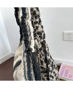 Dettaglio di borsa tote in peluche con stampa leopardata e coulisse laterale regolabile