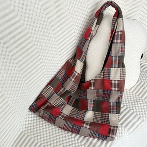 Close-up of retro plaid patchwork tote bag with wide shoulder strap in canvas fabric