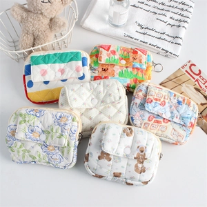 Detailed view of quilted cotton coin purses with floral, bear, and rabbit prints