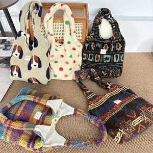Detail view of plush tote bags with various prints on a cozy home background