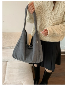 Detail of dark grey wool shoulder bag on model showing thick autumn winter texture