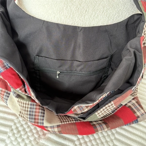 Close-up of the vintage plaid tote bag showing the interior compartment and zipper pocket