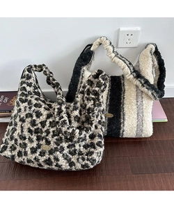 Dettaglio di borse tote in peluche con stampa leopardata e targhetta Handmade
