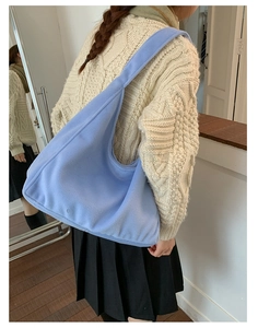 Detail of light blue fuzzy wool tote bag with soft texture and wide shoulder strap