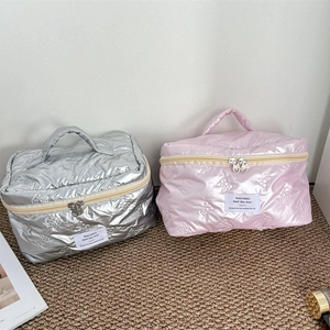 Quilted butterfly cosmetic bags in pink and silver with top handle and zipper closure