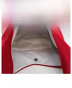 Close-up of red plush tote bag interior with magnetic closure and dual pockets
