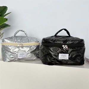 Detail of quilted silver and black makeup bags with cute rabbit patterns and top handle
