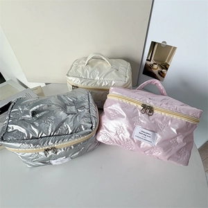 Detailed view of quilted makeup bags with teddy bear pattern and dual metal zippers