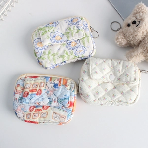 Detailed close-up of three quilted floral mini pouches with snap buttons and keychains