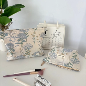 Detailed close-up of blue floral jacquard makeup bags in two sizes for organization