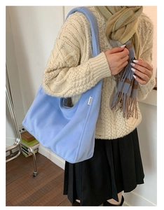 Close-up of a soft light blue faux fur tote bag showing plush texture and YEYU logo tag