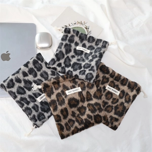 Close-up of leopard print plush drawstring storage pouches for cosmetics and tech gadgets