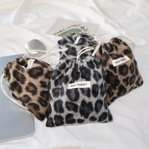 Detail view of leopard print plush drawstring bags with May Rabbit brand label